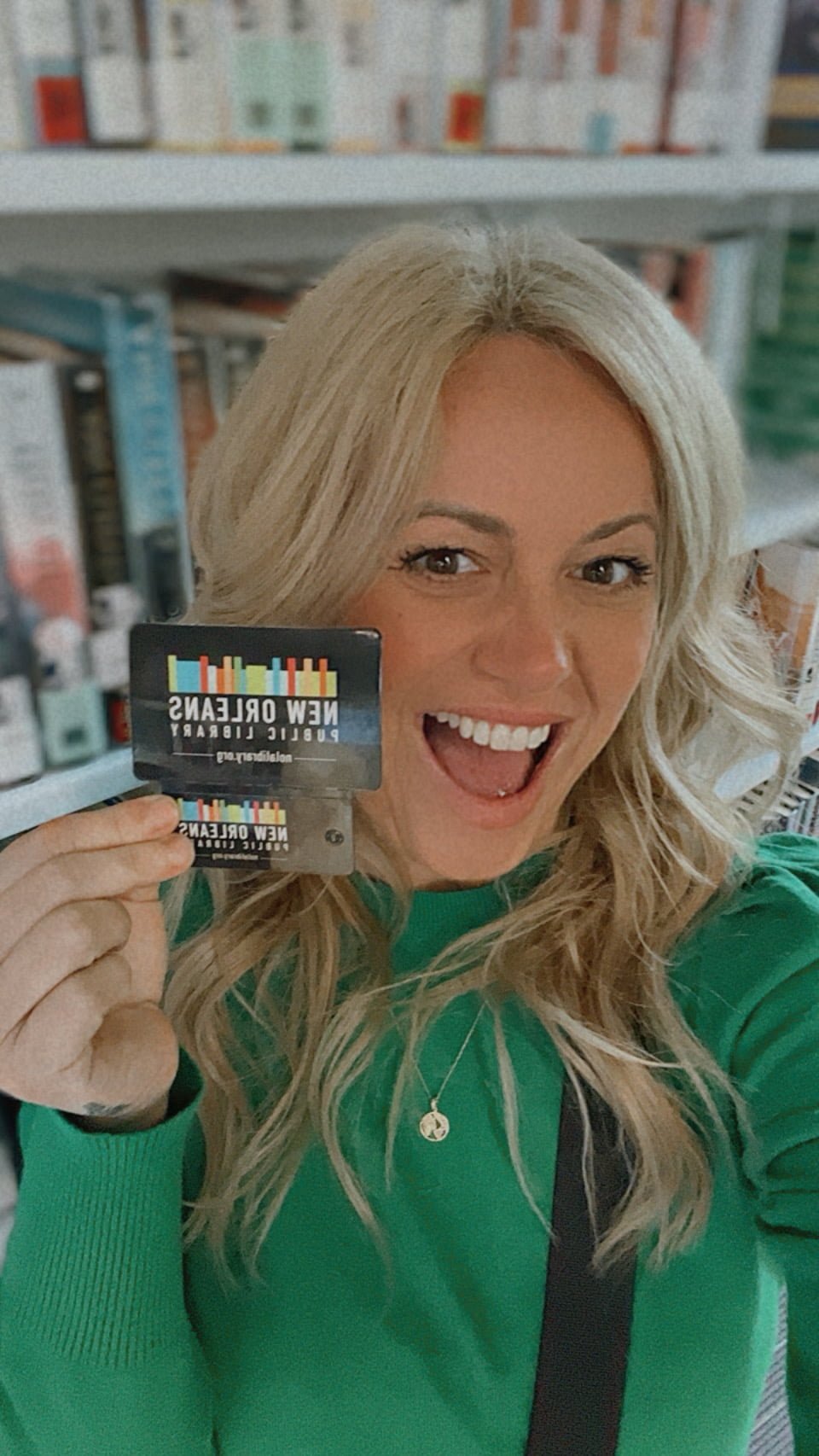 Samantha smiling and holding New Orleans Public Library cards